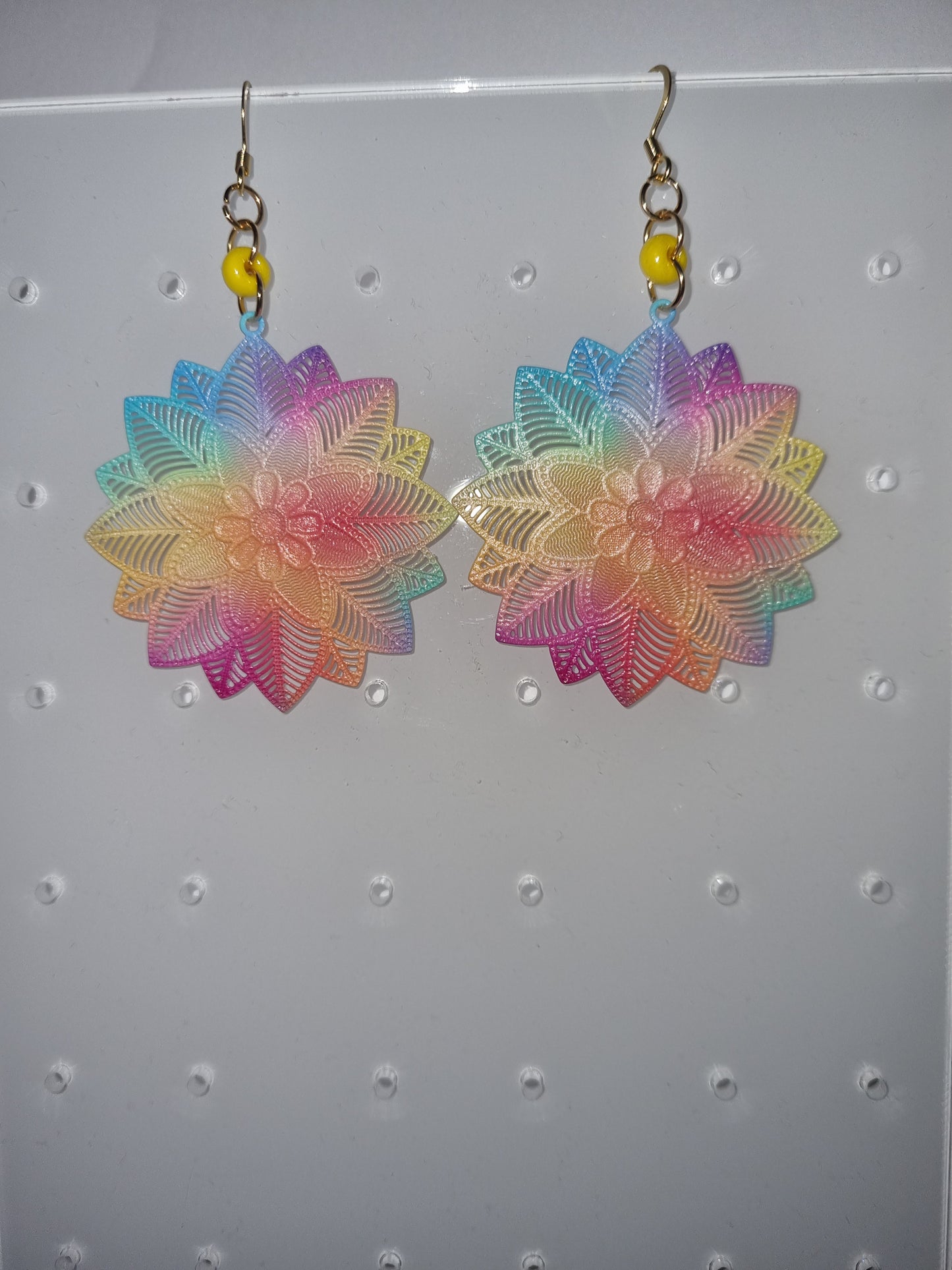 Boucles d'oreilles fantaisie multi couleurs et une perle jaune .